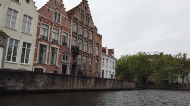 Bruges, Belçika - Mayıs 2019: Şehir merkezindeki su kanalının görünümü. Turist şehrin su kanalları üzerinde yürümek. Bir turist teknesinden görünüm.