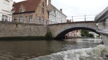 Bruges, Belçika - Mayıs 2019: Şehir merkezindeki su kanalının görünümü. Turist şehrin su kanalları üzerinde yürümek. Bir turist teknesinden görünüm.
