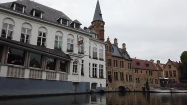Bruges, Belçika - Mayıs 2019: Şehir merkezindeki su kanalının görünümü. Turist şehrin su kanalları üzerinde yürümek. Bir turist teknesinden görünüm.