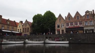 Bruges, Belçika - Mayıs 2019: Şehir merkezindeki su kanalının görünümü. Turist şehrin su kanalları üzerinde yürümek. Bir turist teknesinden görünüm.