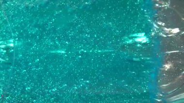 Jeldeki mavi hava kabarcıkları. Mavi arka planda jel ampulleri. Mavi boğalar yakın plan. Ekranda yüzen Bulbashki. 