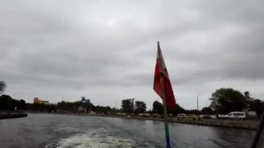 Gdansk, Polonya - Eylül 2019: Bir geminin güvertesinde motordan gelen dalgaların arka planına karşı Polonya bayrağı gelişiyor. Geminin güvertesinden rıhtımın su kanalı.