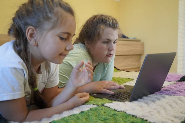 Mädchen im Alter von sieben und zwölf Jahren arbeiten im Zimmer an einem Laptop — Stockfoto