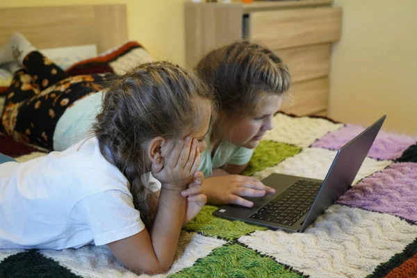 Mädchen im Alter von sieben und zwölf Jahren arbeiten im Zimmer an einem Laptop — Stockfoto