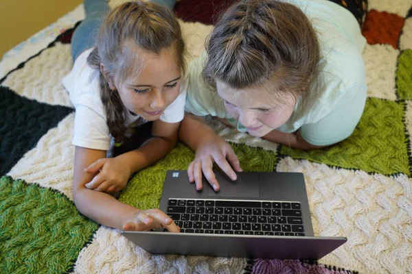 Mädchen im Alter von sieben und zwölf Jahren arbeiten im Zimmer an einem Laptop — Stockfoto