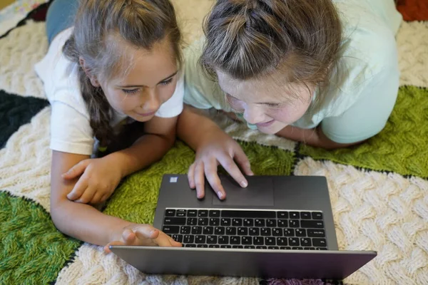 Mädchen im Alter von sieben und zwölf Jahren arbeiten im Zimmer an einem Laptop — Stockfoto