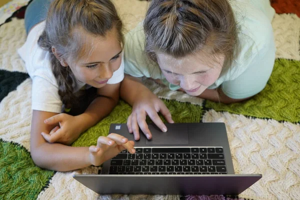Mädchen im Alter von sieben und zwölf Jahren arbeiten im Zimmer an einem Laptop — Stockfoto
