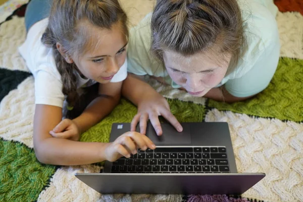 Mädchen im Alter von sieben und zwölf Jahren arbeiten im Zimmer an einem Laptop — Stockfoto