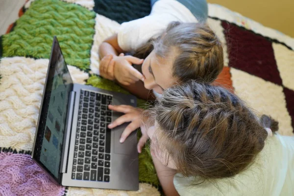 Mädchen im Alter von sieben und zwölf Jahren arbeiten im Zimmer an einem Laptop — Stockfoto