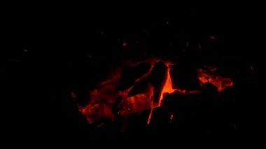 Sparks from a fire scatter on a black background. Sparks from a barbecue in the dark.