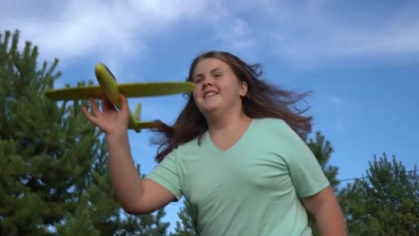 德国柏林 2019年10月 一个女孩在松树和蓝天的背景下发射了一架玩具飞机 在大自然的背景下玩玩具飞机的女孩 — 图库视频影像