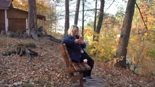 Flicka Sitter Bänk Använder Smartphone Bakgrunden Sjön Och Höstskogen Flicka — Stockvideo