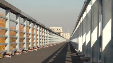 Şehrin siluetinin arka planına karşı tamamlanmamış köprü. Bitmemiş otoyol kenti. Otobanda çamurluk.