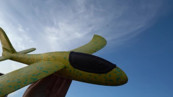 おもちゃの飛行機のクローズアップは 青い空の本当の飛行機に置き換えられます — ストック動画