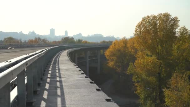 街のシルエットを背景に未完成の橋 未完成の高速道路離れた都市 アウトバーンのフェンダー — ストック動画
