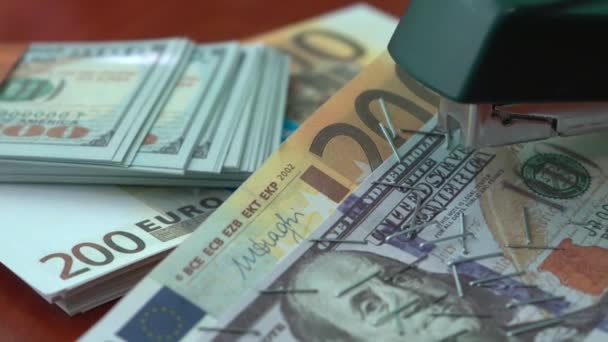 订书机用铁夹子固定美元和欧元纸币 钉书机 背景上的纸夹在钞票上 — 图库视频影像