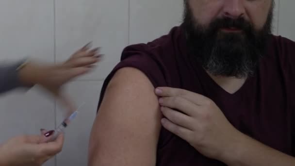 Kiew, Ukraine, Europa - Oktober 2019: Impfung gegen das Virus. eine Krankenschwester gibt einem bärtigen Mann eine Spritze.
