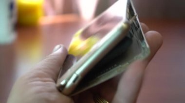 Şişmiş akıllı telefon pili. Bozuk pilli, hasarlı bir akıllı telefon. Ahşap bir arka planda hasarlı telefon.