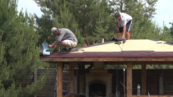 Europe, Kiev region, Ukraine - June 2020: Builders cover the roof with a wooden arbor. Construction of a wooden gazebo. Catopal laying. — Stock Footage Europe Kiev Region Ukraine June 2020 Builders Cover Roof Wooden Royalty Free Stock Footage
