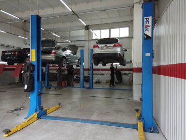 Avrupa, Kiev, Ukrayna - Temmuz 2020: Teknik bir denetim istasyonundaki otomobil egzoz sisteminin tamiri. Araba tamircisi araba tamiri yapar, kaynak yapar..