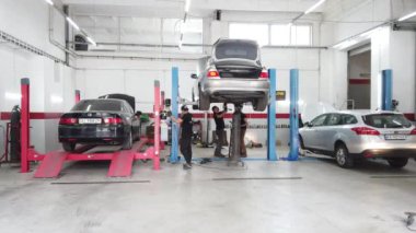 Avrupa, Kiev, Ukrayna - Temmuz 2020: Teknik bir denetim istasyonundaki otomobil egzoz sisteminin tamiri. Araba tamircisi araba tamiri yapar, kaynak yapar..