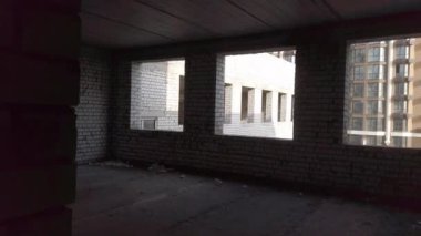 Bitmemiş ev inşaatı. İnşaat alanının arka planında beyaz tuğla var. İnşaat manzarası içeriden. Binanın iç onarım çalışmaları..