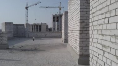 Bitmemiş ev inşaatı. İnşaat alanının arka planında beyaz tuğla var. İnşaat manzarası içeriden. Binanın iç onarım çalışmaları..