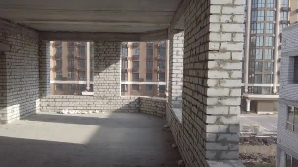 Unvollendeter Hausbau. Weißer Backstein auf dem Hintergrund der Baustelle. Blick auf den Bau von innen. Interne Reparaturarbeiten des Betriebsgeländes. — Stockvideo