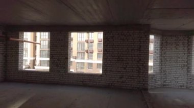 Bitmemiş ev inşaatı. İnşaat alanının arka planında beyaz tuğla var. İnşaat manzarası içeriden. Binanın iç onarım çalışmaları..