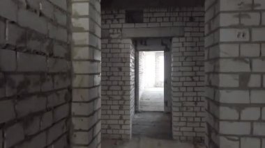 Bitmemiş ev inşaatı. İnşaat alanının arka planında beyaz tuğla var. İnşaat manzarası içeriden. Binanın iç onarım çalışmaları..