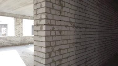 Bitmemiş ev inşaatı. İnşaat alanının arka planında beyaz tuğla var. İnşaat manzarası içeriden. Binanın iç onarım çalışmaları..