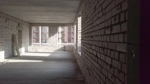 Κατασκευή ημιτελών σπιτιών. Λευκό τούβλο στο φόντο του εργοταξίου. Θέα από μέσα. Εργασίες εσωτερικής επισκευής των χώρων. — Αρχείο Βίντεο