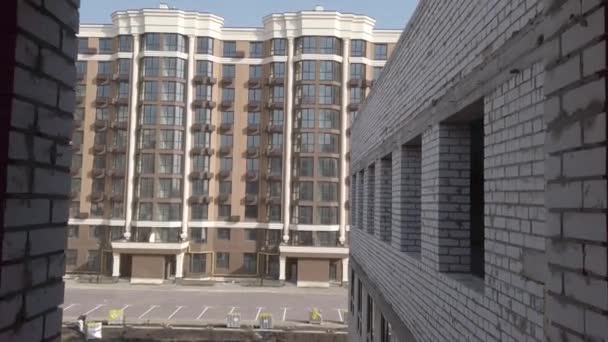 Unvollendeter Hausbau. Weißer Backstein auf dem Hintergrund der Baustelle. Blick auf den Bau von innen. Interne Reparaturarbeiten des Betriebsgeländes. — Stockvideo