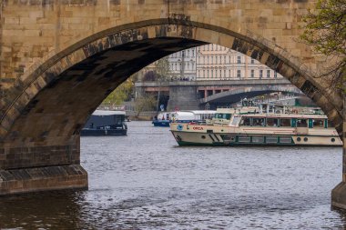 Prag, Çek Cumhuriyeti - 5 Nisan 2025: Charles Köprüsü ve Vltava Nehri 'nin yanından geçen gemileri görmek.
