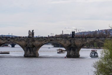 Prag, Çek Cumhuriyeti - 5 Nisan 2025: Charles Köprüsü ve Vltava Nehri 'nin yanından geçen gemileri görmek.