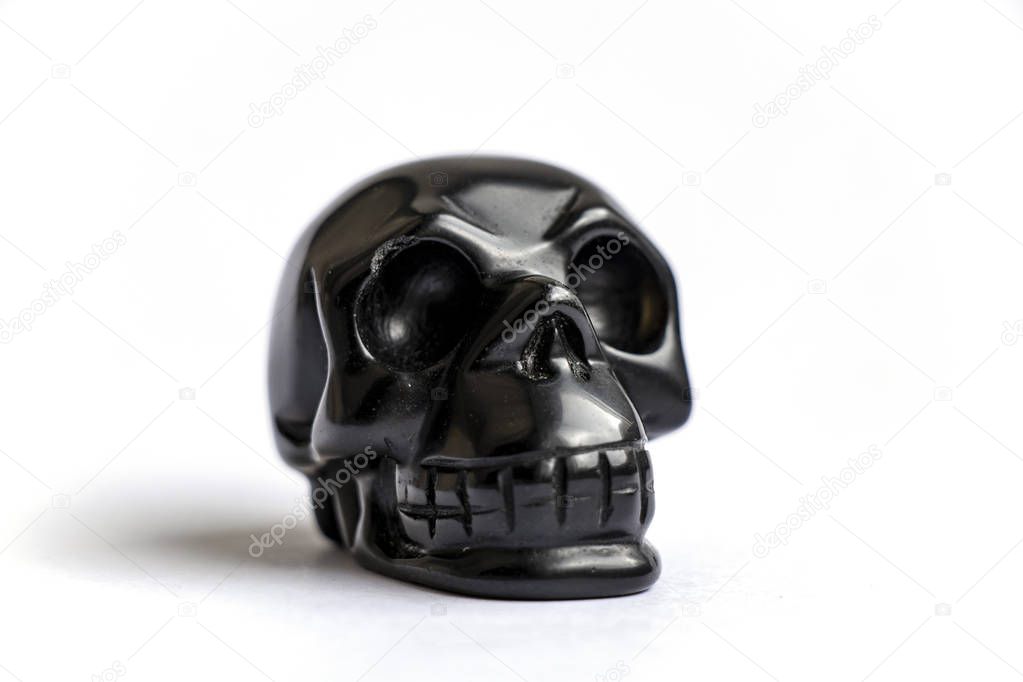 black skull made of stone on a white background