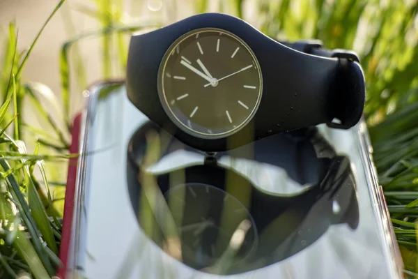 Силиконовые Черные Наручные Часы Лежат Траве Сенсорном Телефоне Солнце — стоковое фото