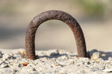 beton bir blok üzerine monte edilmiş eski paslı menteşe