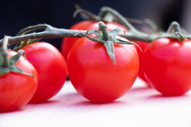 Çeri domatesler dalların üzerinde güneşli bir günde bahçede, sokaklarda.