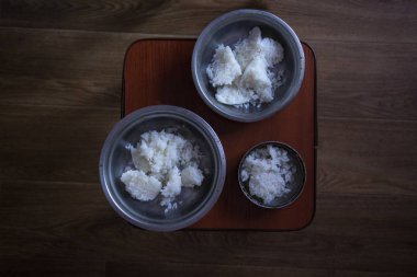 Mutfaktaki sandalyenin üzerinde pirinç lapası olan üç kase demir. Köpekler için kahvaltı.