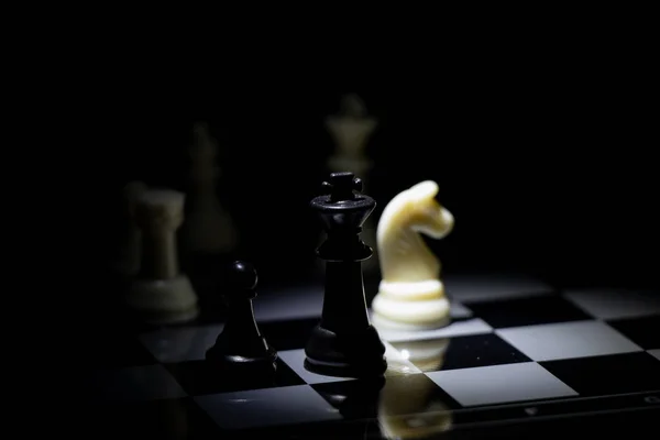 Sakkfigurák Sakktáblán Egy Sötét Szobában Lámpával Megvilágítva — Stock Fotó