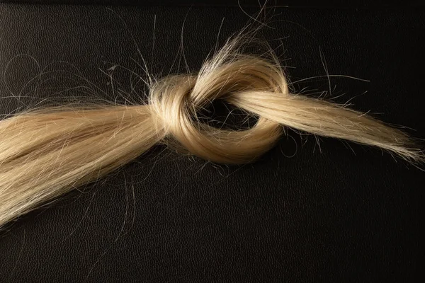 Gestrickt Einem Knoten Aus Weiblichen Blonden Haaren Auf Einem Schwarzen — Stockfoto