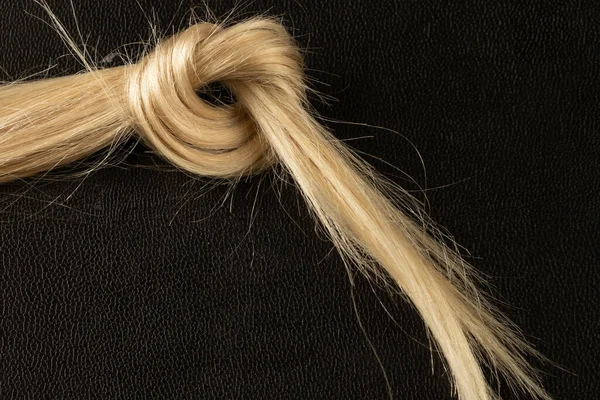 Gestrickt Einem Knoten Aus Weiblichen Blonden Haaren Auf Einem Schwarzen — Stockfoto