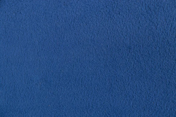 plain dark blue fabric made of artificial materials as a wallpaper