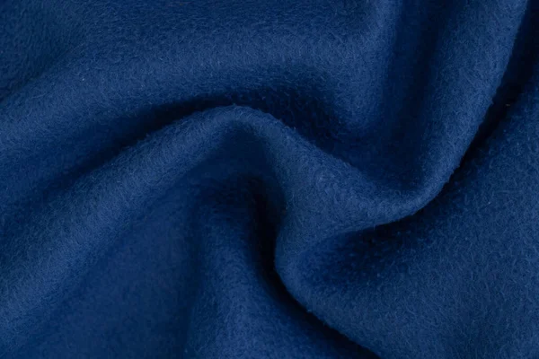 plain dark blue fabric made of artificial materials as a wallpaper