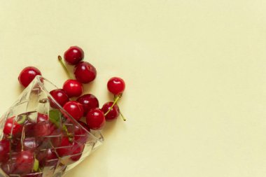 Olgun kirazlar kırmızı arka planda bir bardakta