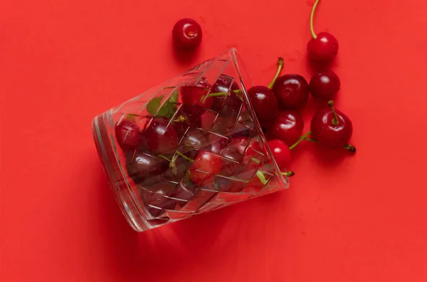 Cerezas Maduras Vaso Sobre Fondo Rojo —  Fotos de Stock