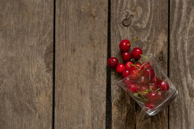 Tahta bir masada, bardakta kiraz.