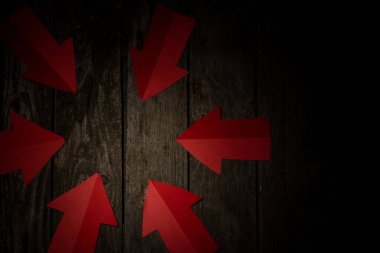 Kağıt oklar koyu arkaplanda masanın merkezini gösteriyor.