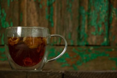 Masasında bitki çayı olan şeffaf bir bardak.